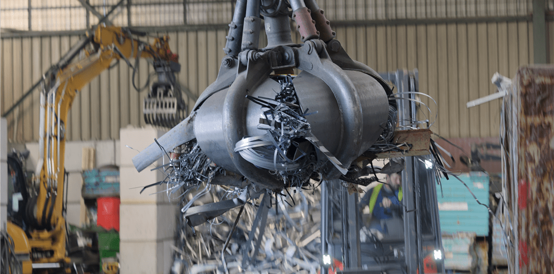 clamshell grabbing scrap in a scrap metal recycling