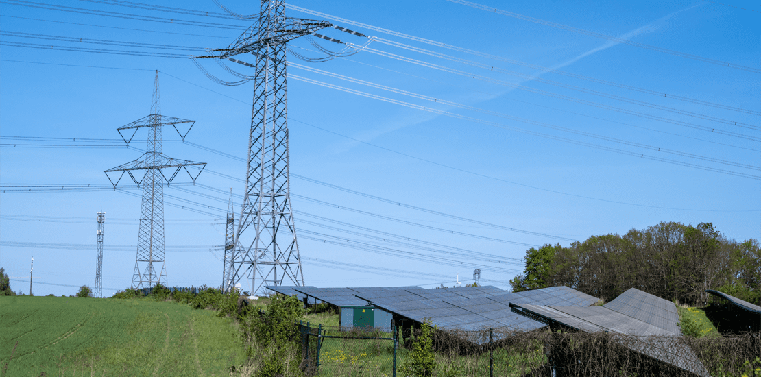 power lines with pylons and a solar power plant