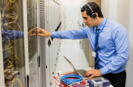 technician in head phones using laptop